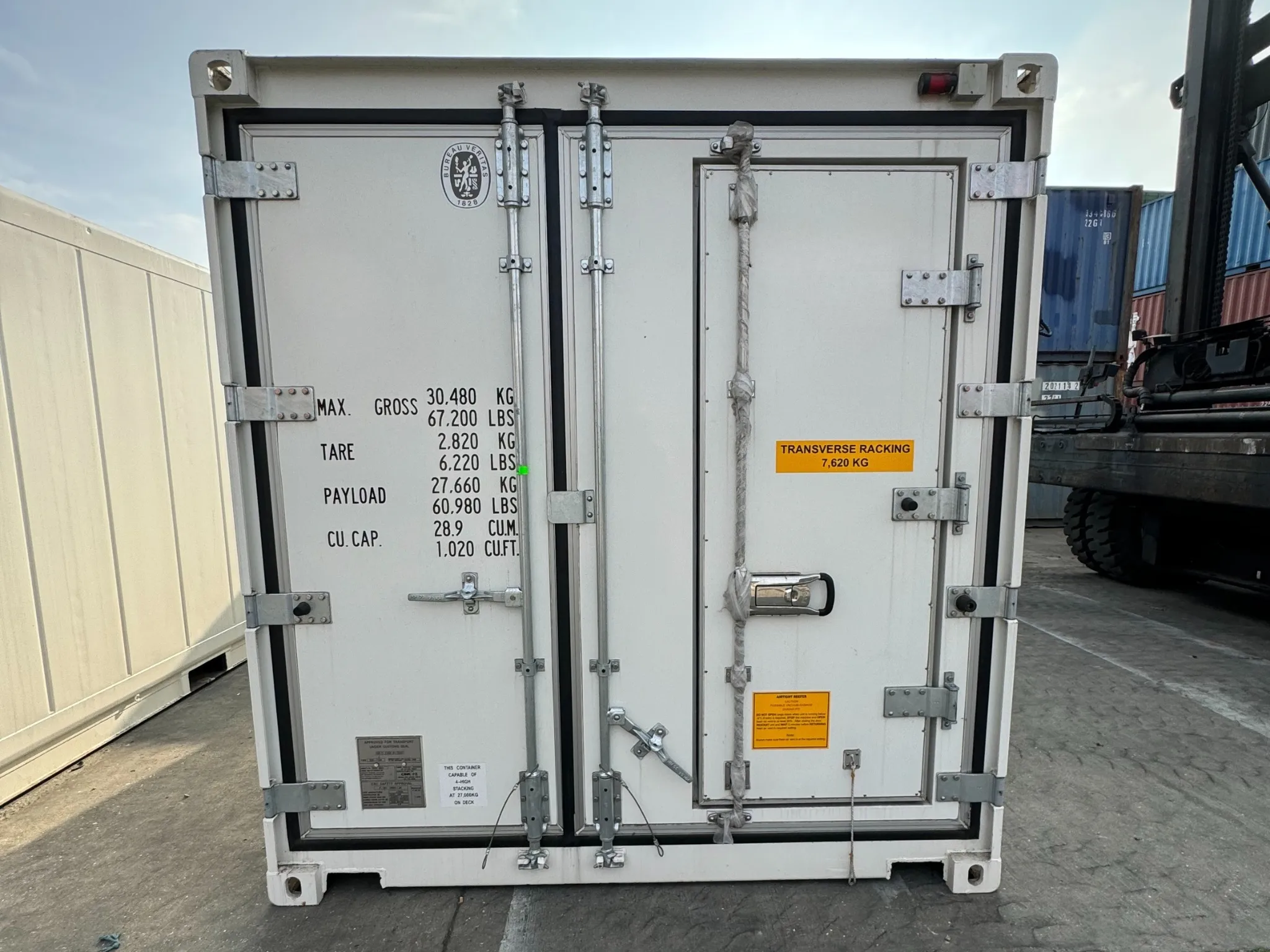Doors of a 20ft new one trip reefer container showing weight capacity and safety labels.
