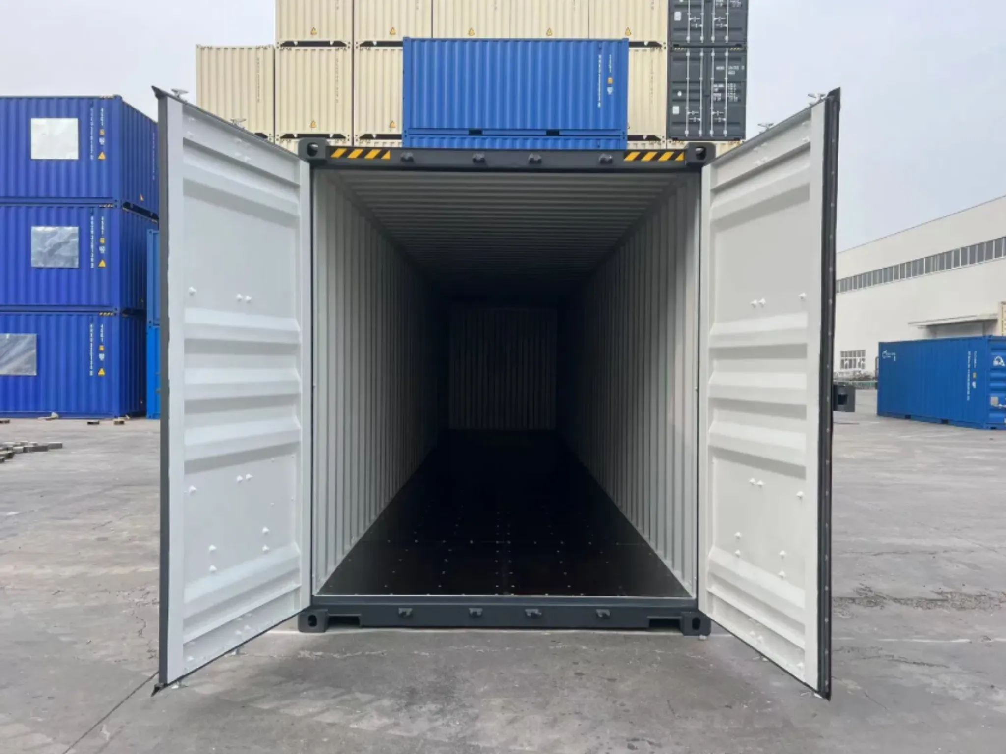 Interior view of a new 40ft high cube shipping container with open double doors, showing clean steel walls and floor.
