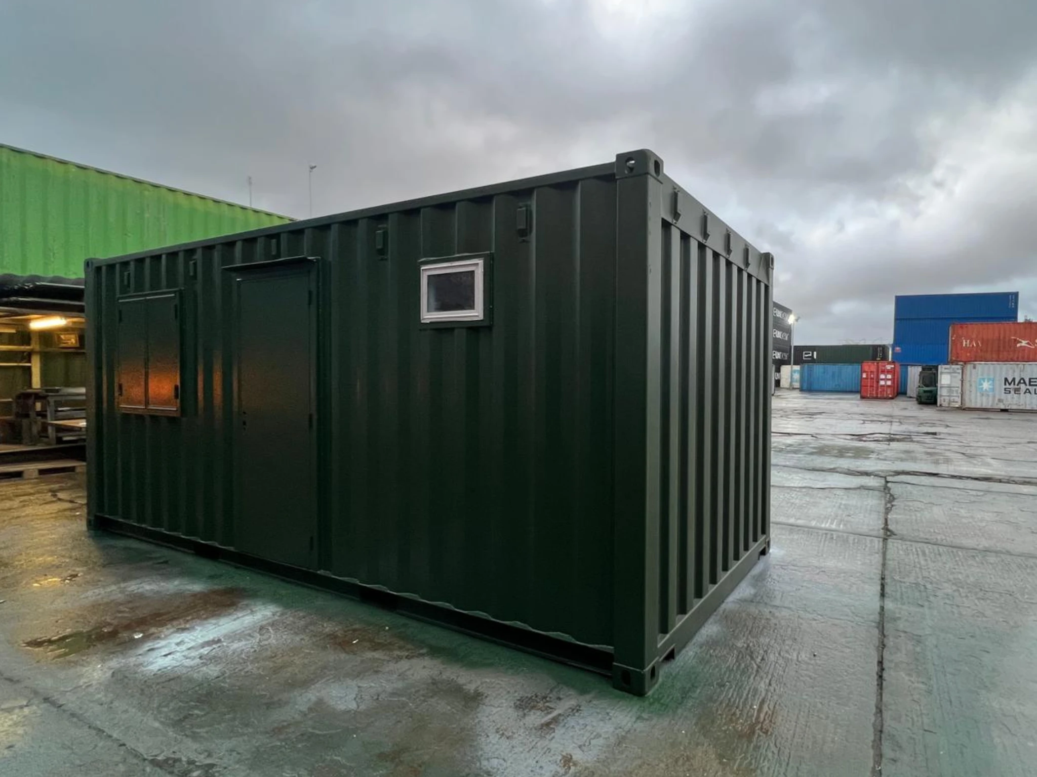Converted shipping container exterior with secure door and windows