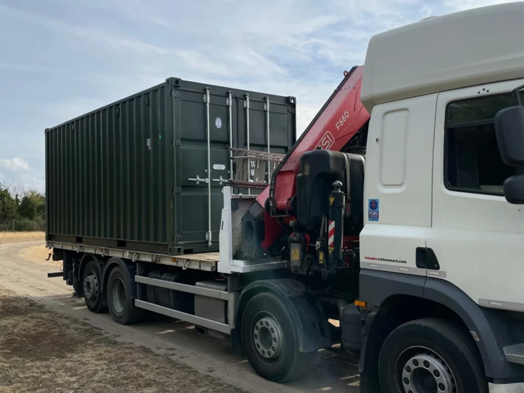 HIAB truck unloading shipping container at customer site