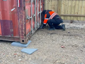 Can You Put a 10ft Shipping Container in a Garden? Shipping container being levelled on concrete paving slabs during delivery to prevent door racking and extend lifespan