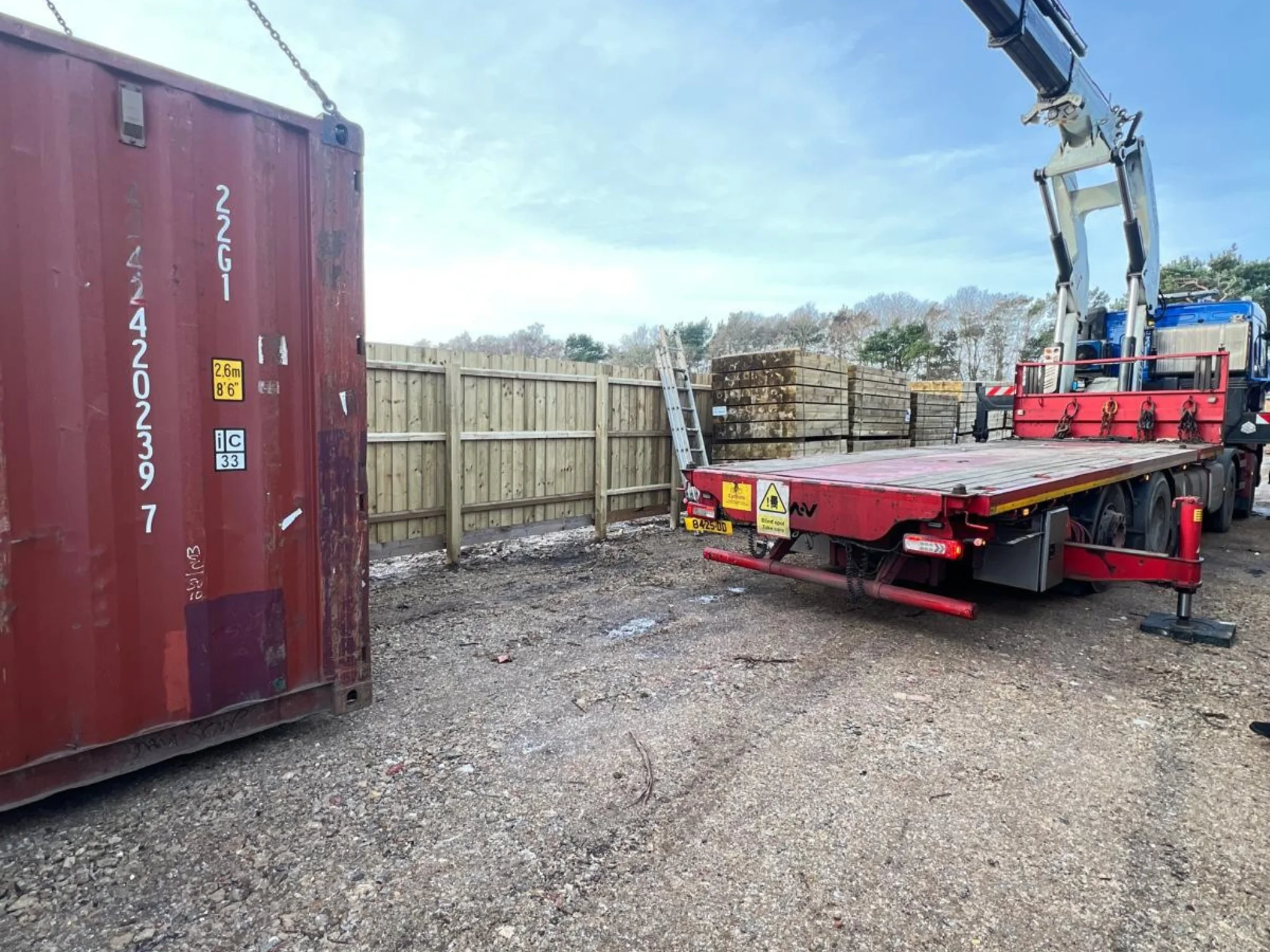 Shipping container being levelled on concrete paving slabs during delivery to prevent door racking and extend lifespan